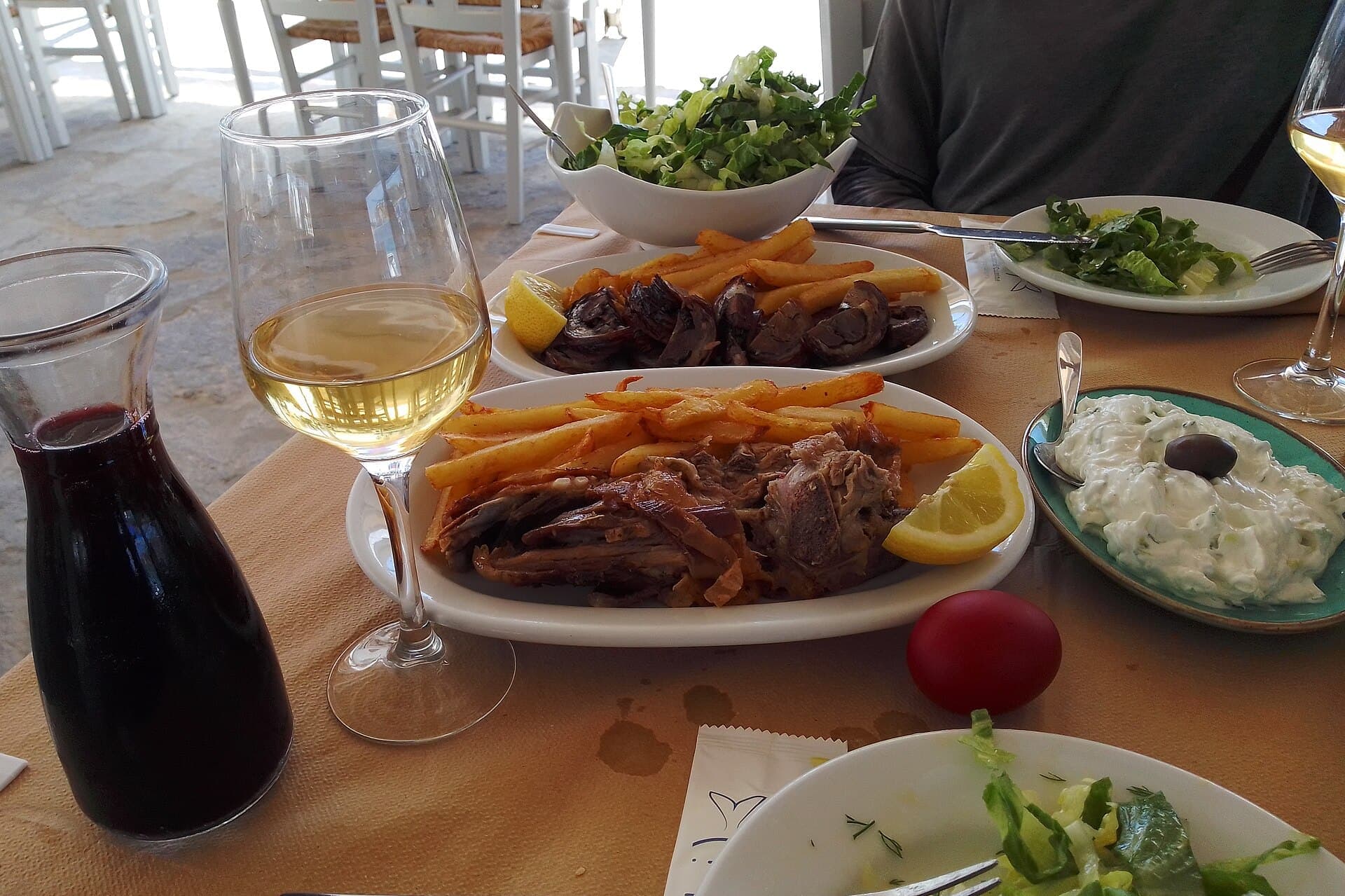 Πασχαλινό τραπέζι με ψητό αρνί, σαλάτες και κρασί