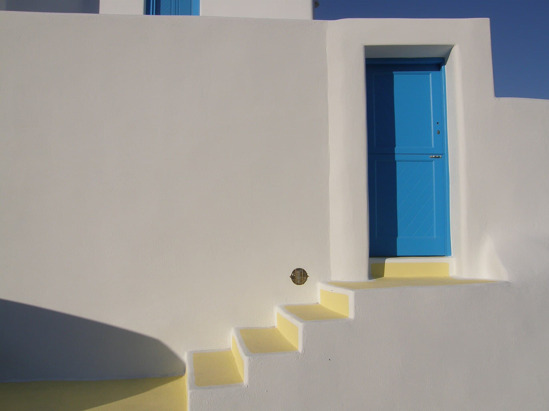 Blue door in a whitewashed wall on a Greek island