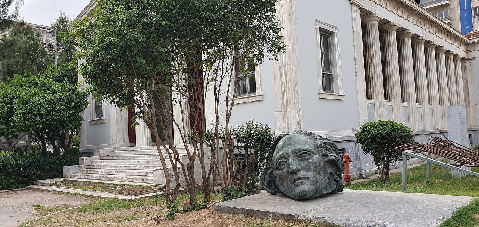 The bronze head of the Polytechnic memorial among the trees