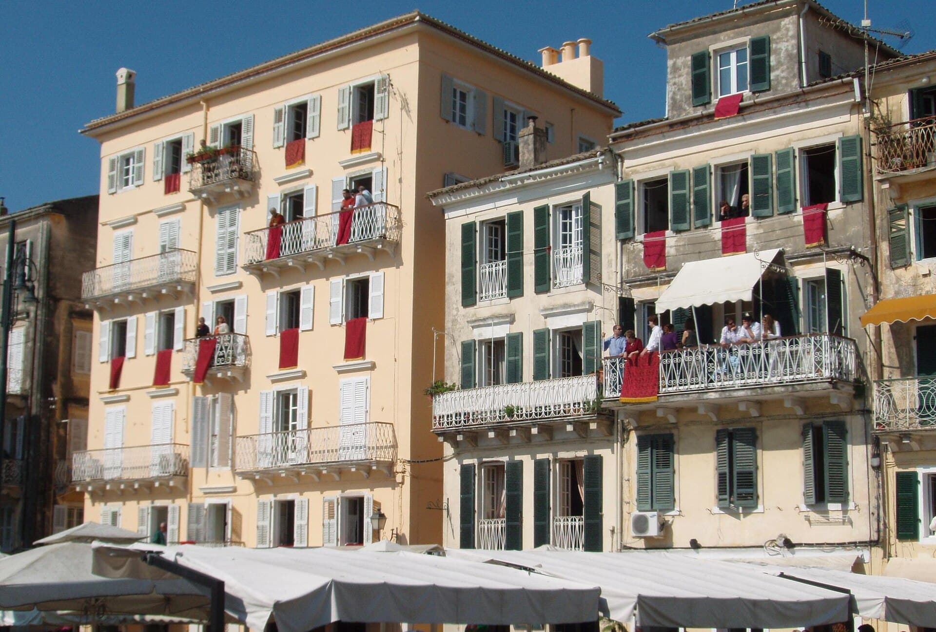 Red cloths hang from Corfu balconies on Holy Saturday before the pots are thrown