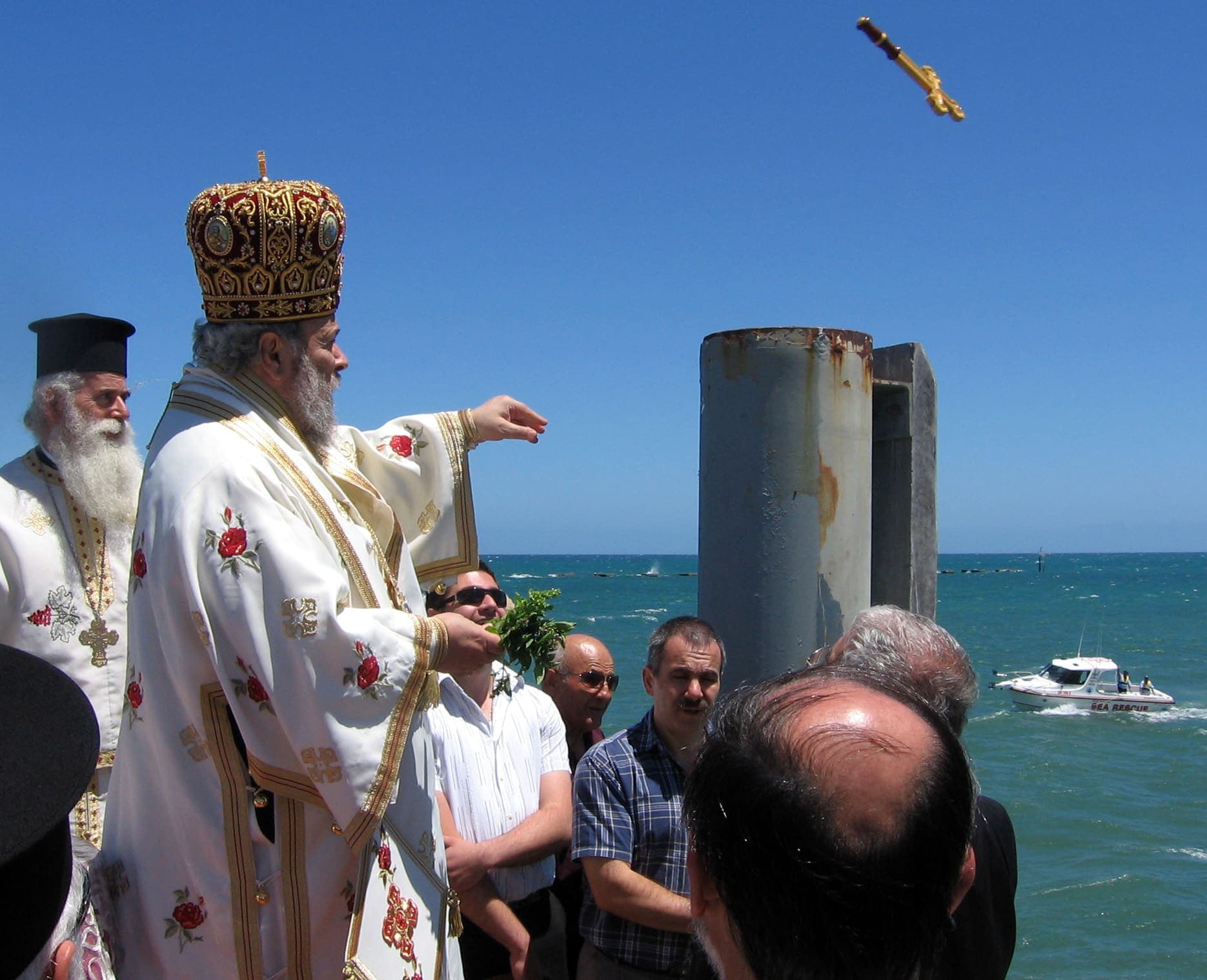 A priest throws the cross into the sea at Theophany